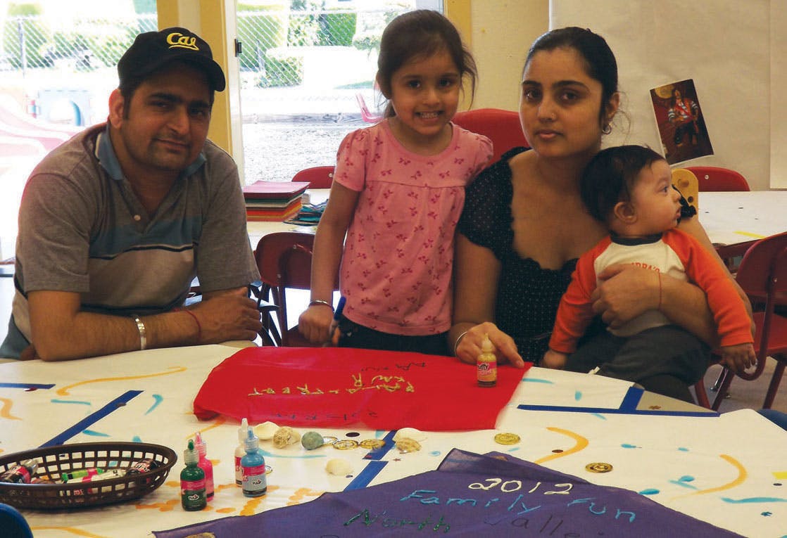 Adults and children at a table with craft supplies