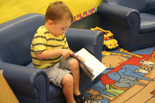 Child sitting in a chair reading a book
