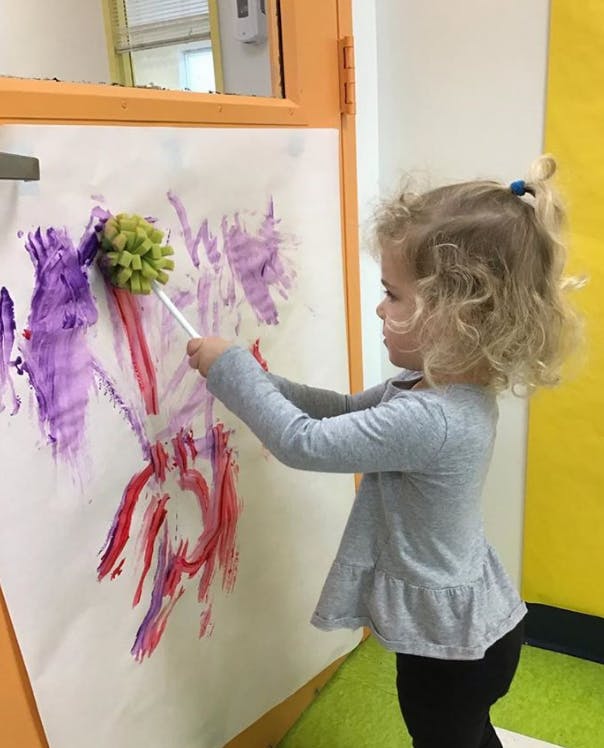 Child painting with a sponge brush