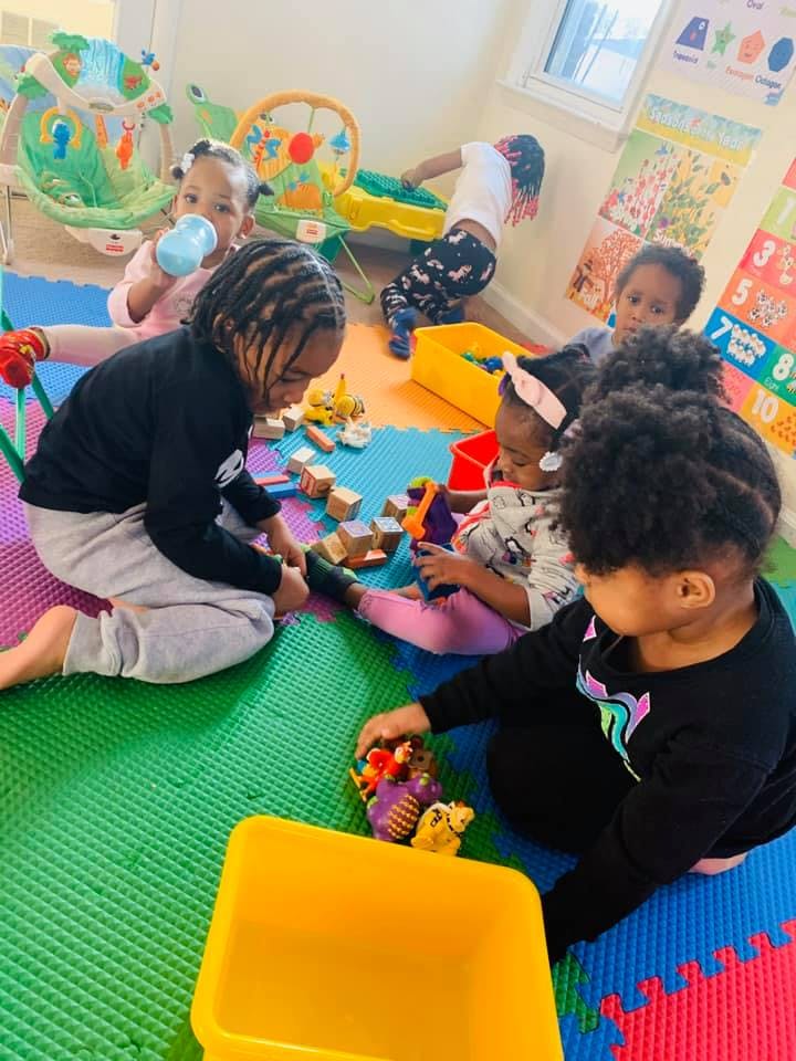 Children playing with toys on a colorful mat