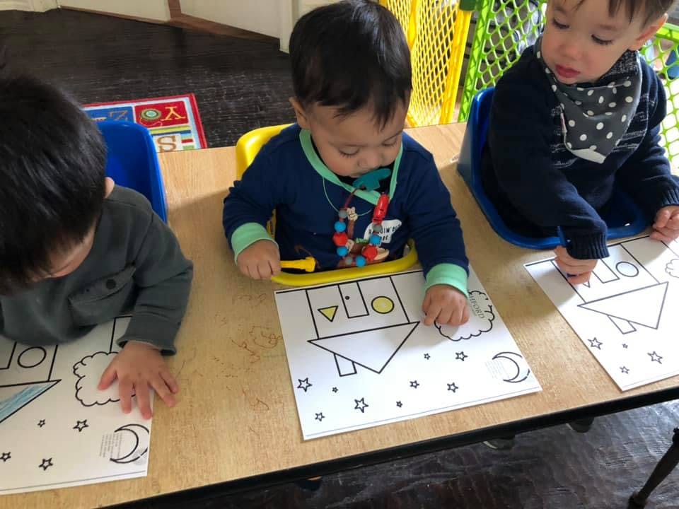 Three children coloring at a table