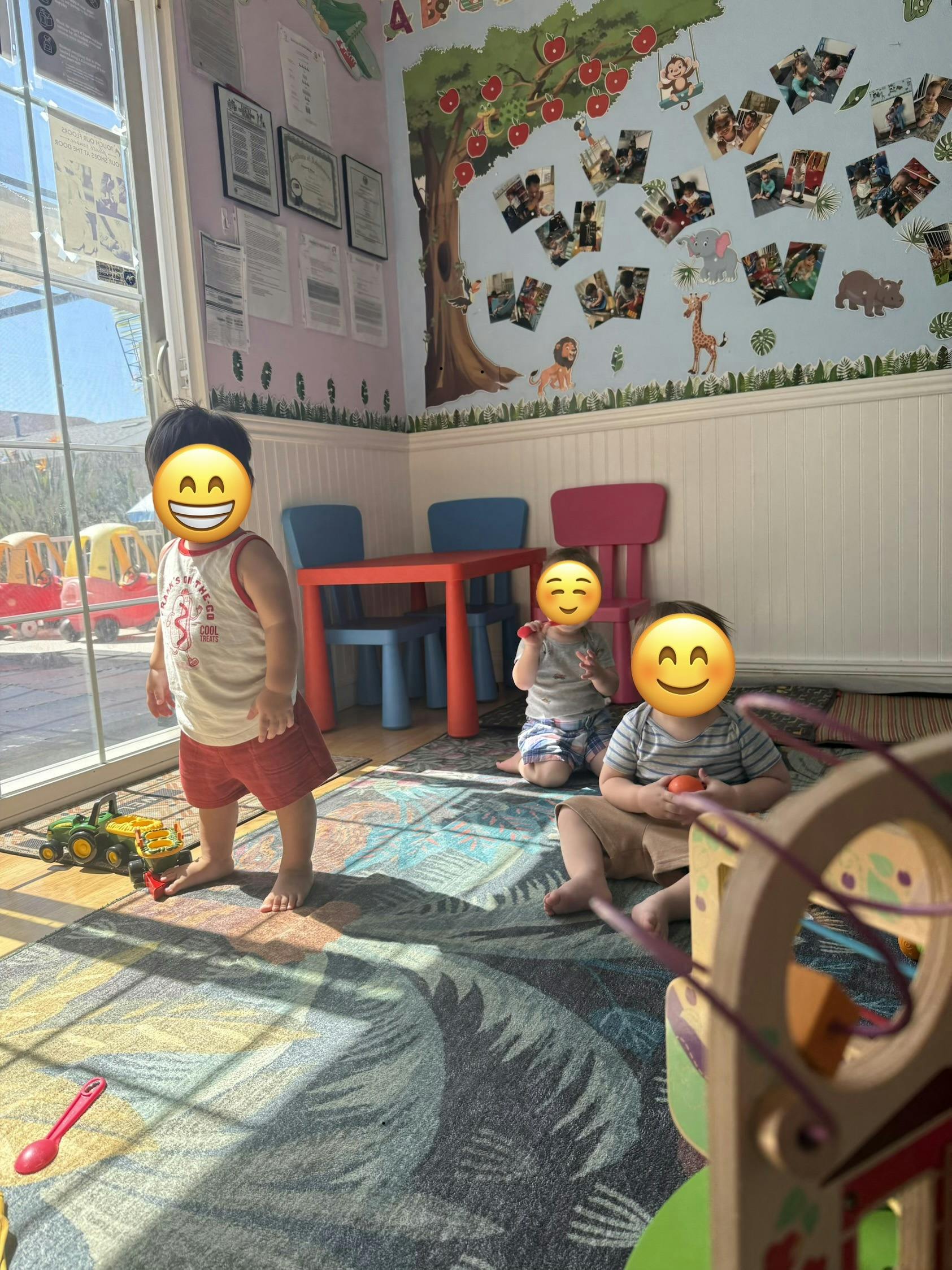 Three children playing with toys on a patterned rug in a room