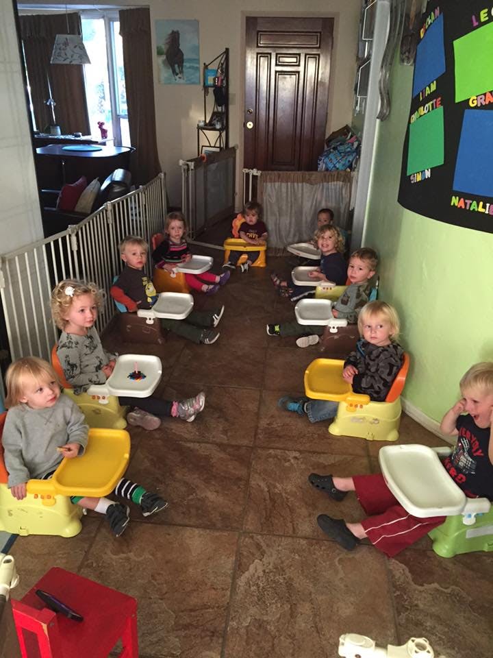 Multiple children sitting in high chairs on a floor