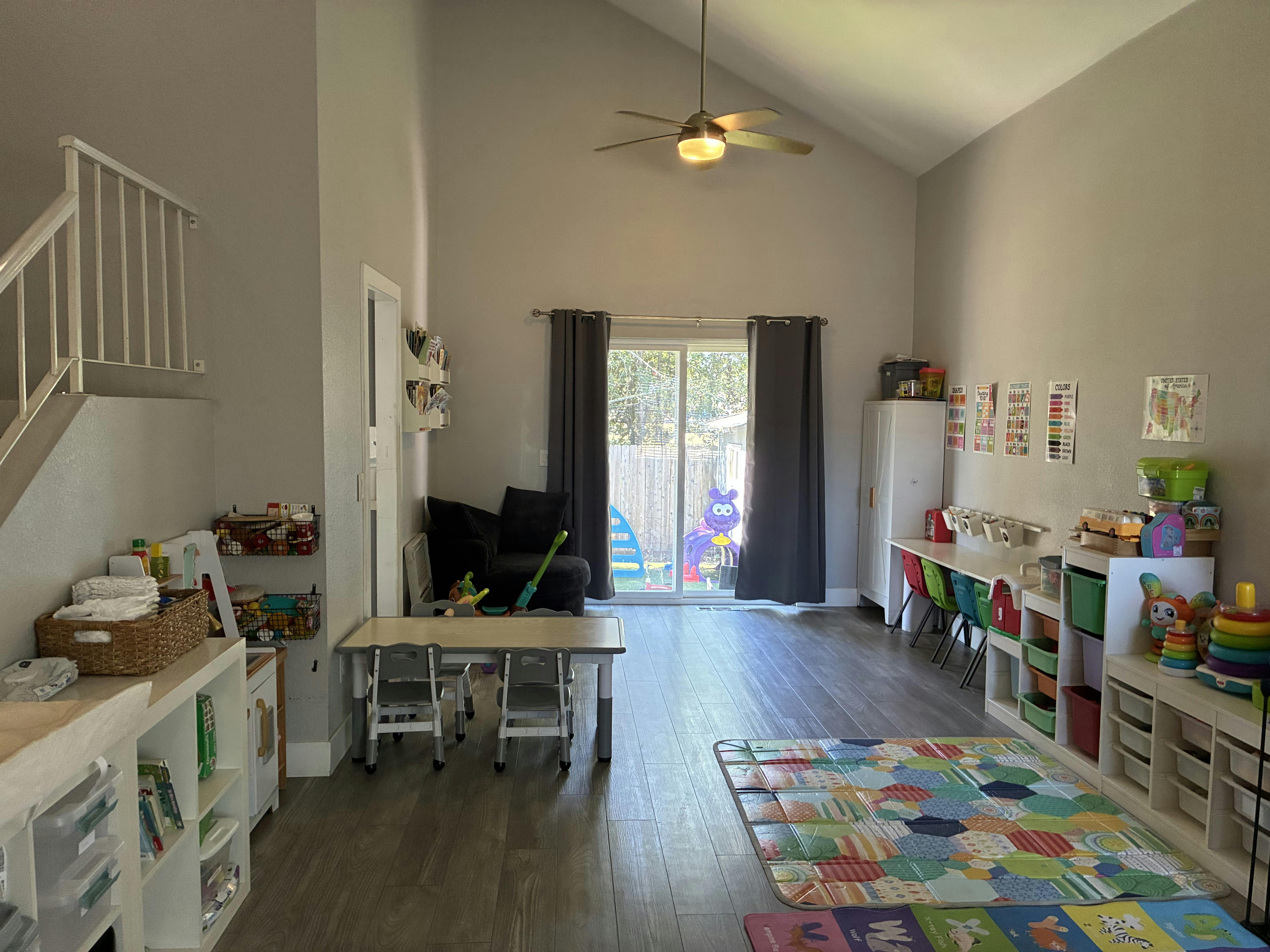 Playroom with children's furniture, rugs, and educational wall posters