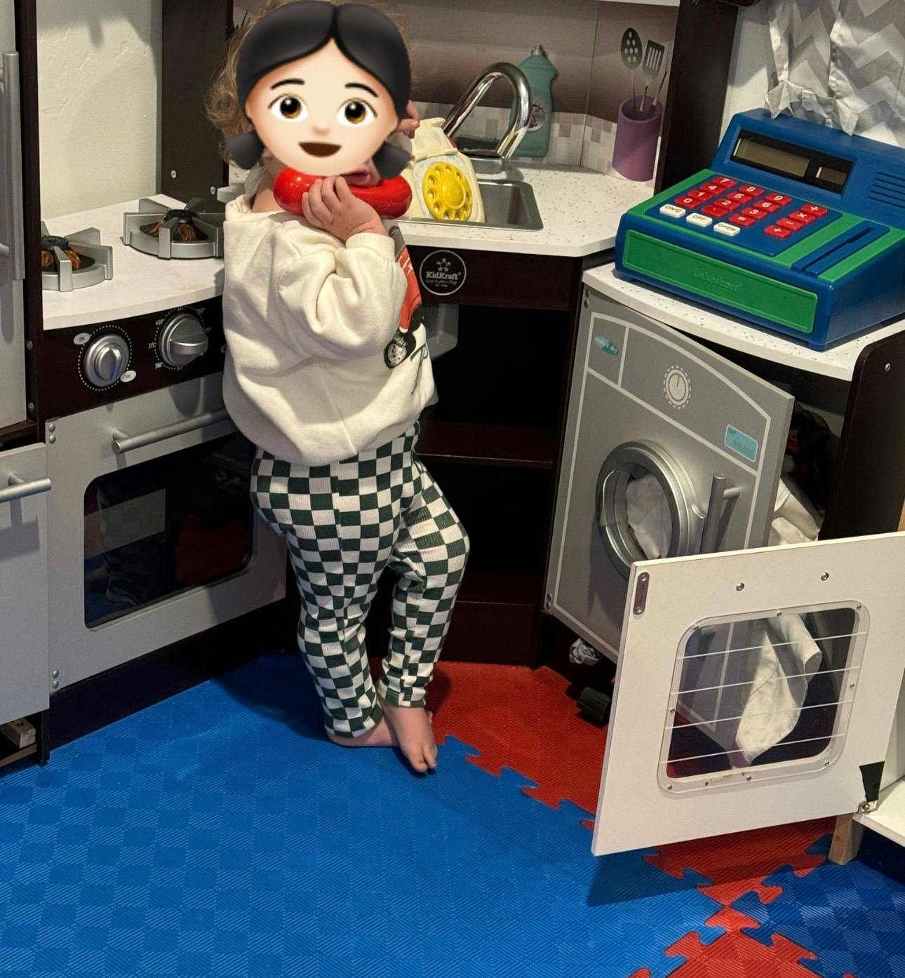 Child playing with a toy kitchen