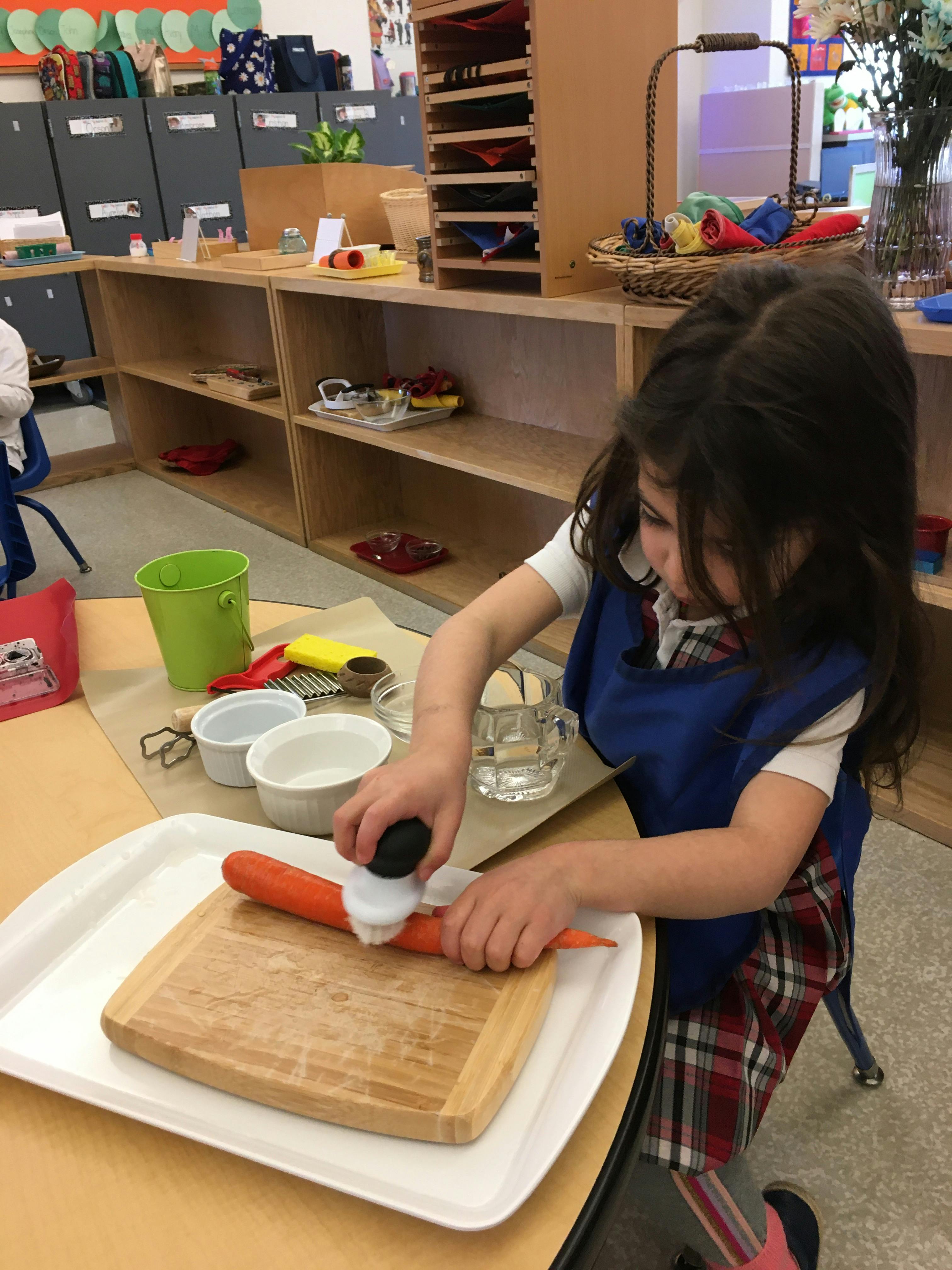 Child peeling a carrot on a cutting board