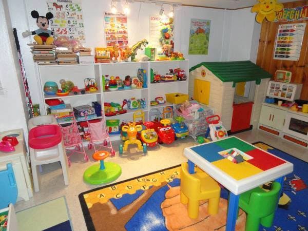 Playroom with shelves of toys, a playhouse, and a colorful table with chairs