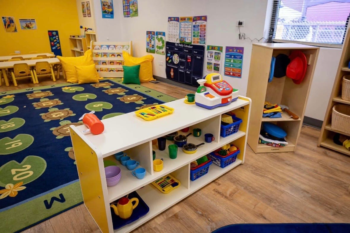 Playroom with toys and a rug featuring turtles and lily pads with numbers