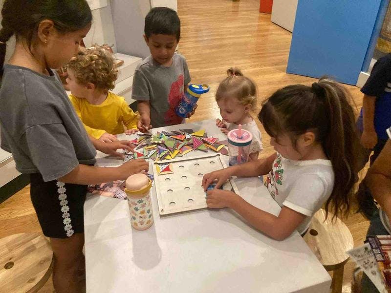 Children playing with puzzles and toys at a table