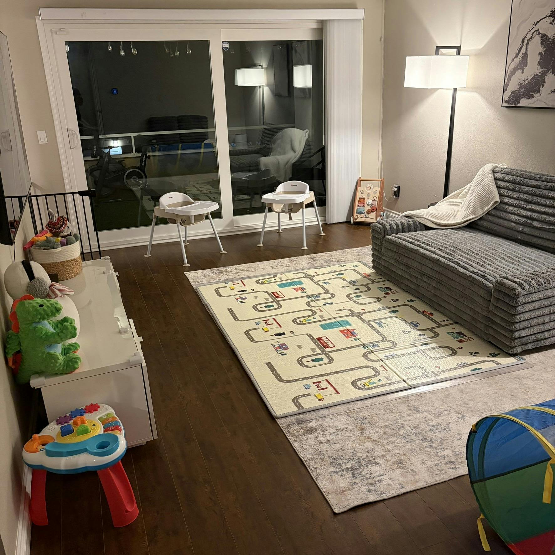 Living room set up as a child playroom with floor mats and toys
