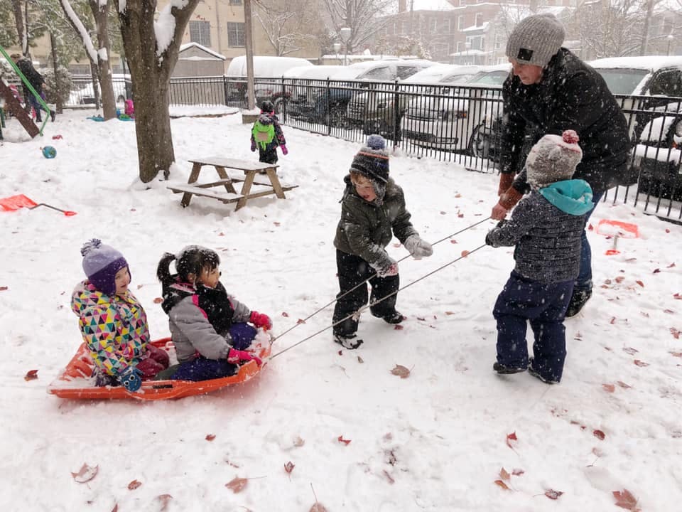 Person pulling children on a sled in the snow