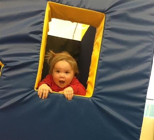 Child looking out of a window in a play structure