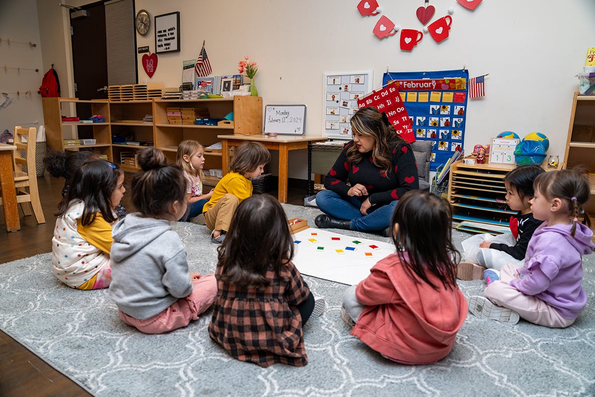 Adult and children sitting on floor in classroom