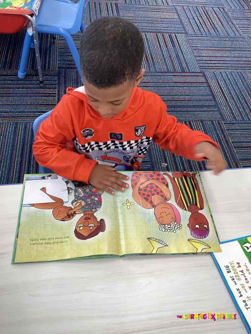 Child looking at an open book with illustrations of people