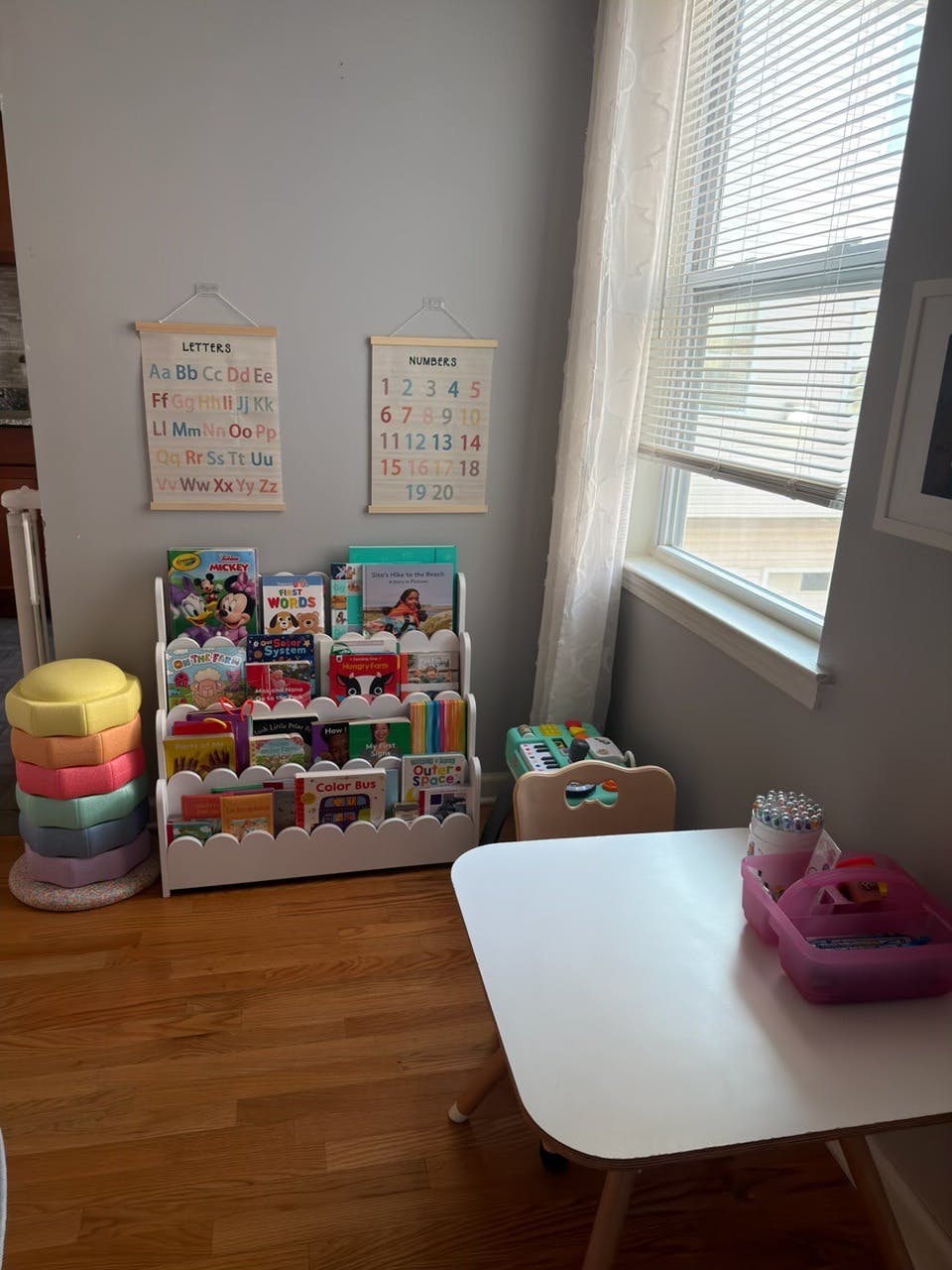 Children's playroom area with a book display, small table, and educational decor