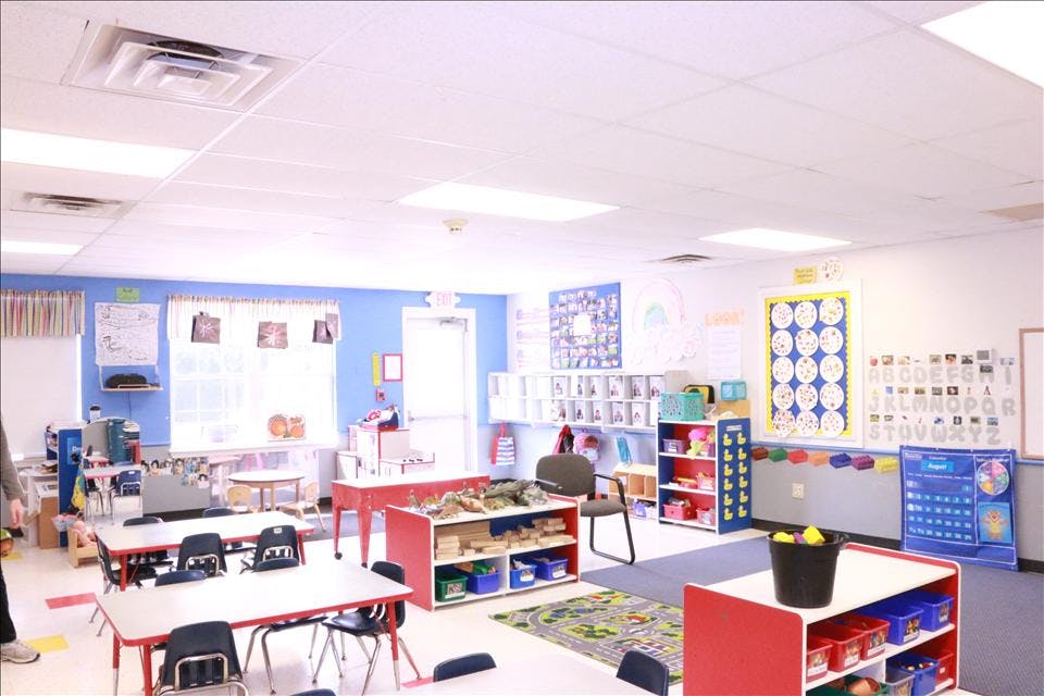 A colorful empty classroom with small tables and chairs