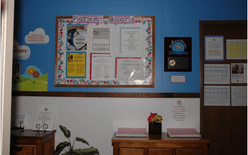 Parent Board with various papers and a plaque on a blue wall