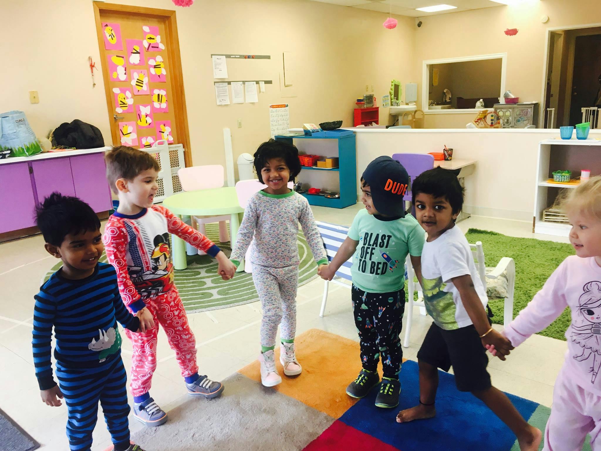 Group of children holding hands in a circle in a classroom