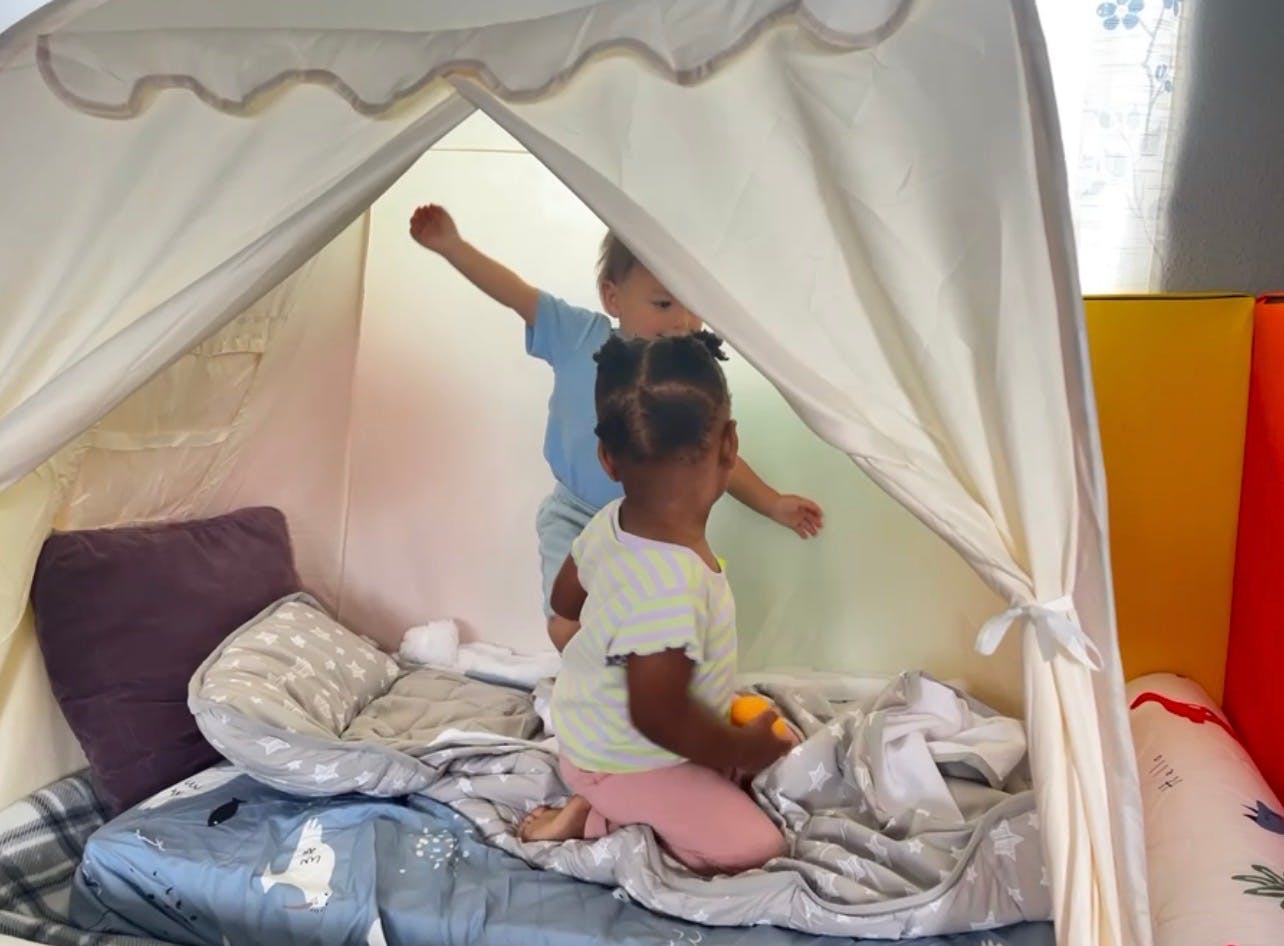 Two children playing inside a fabric play tent