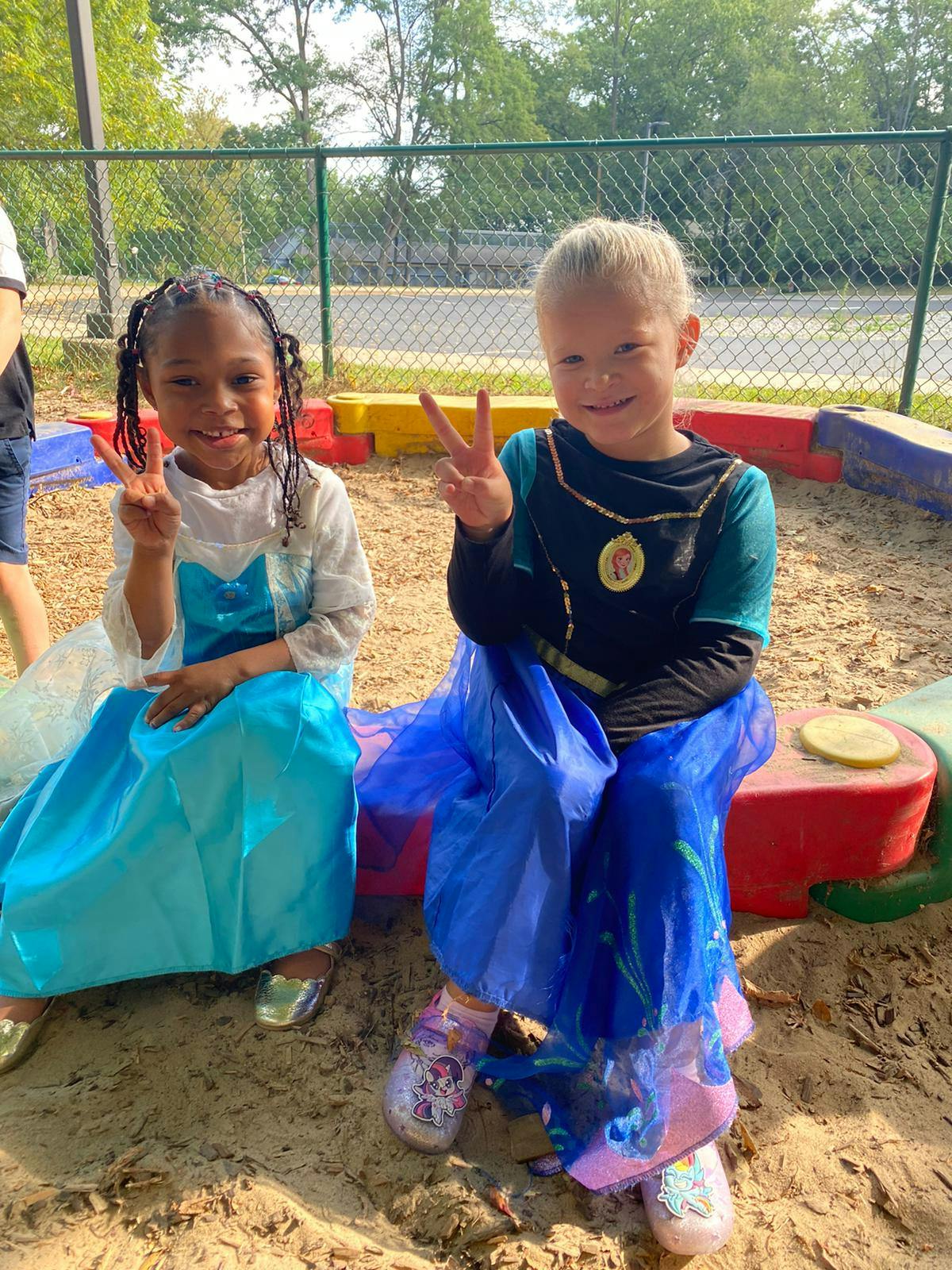 Two children in costumes making peace signs