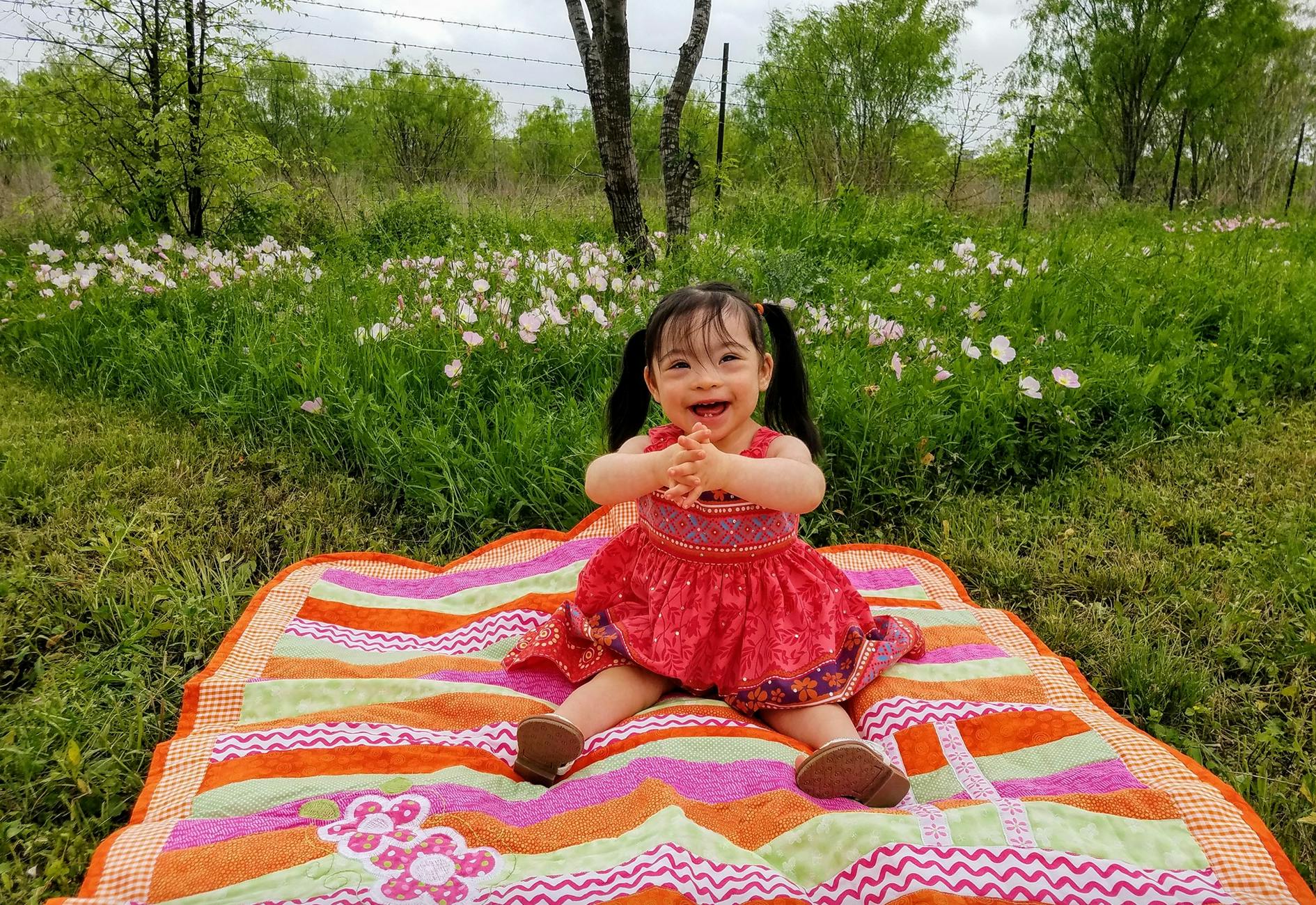 Child sitting on a blanket in a field