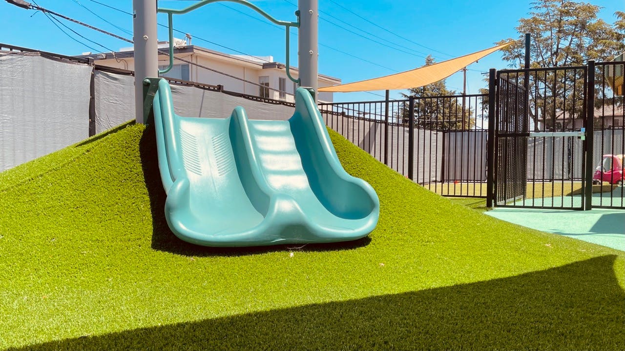 Playground slide on a grassy hill