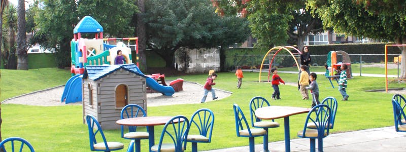 Children playing on a playground with slides and playhouses