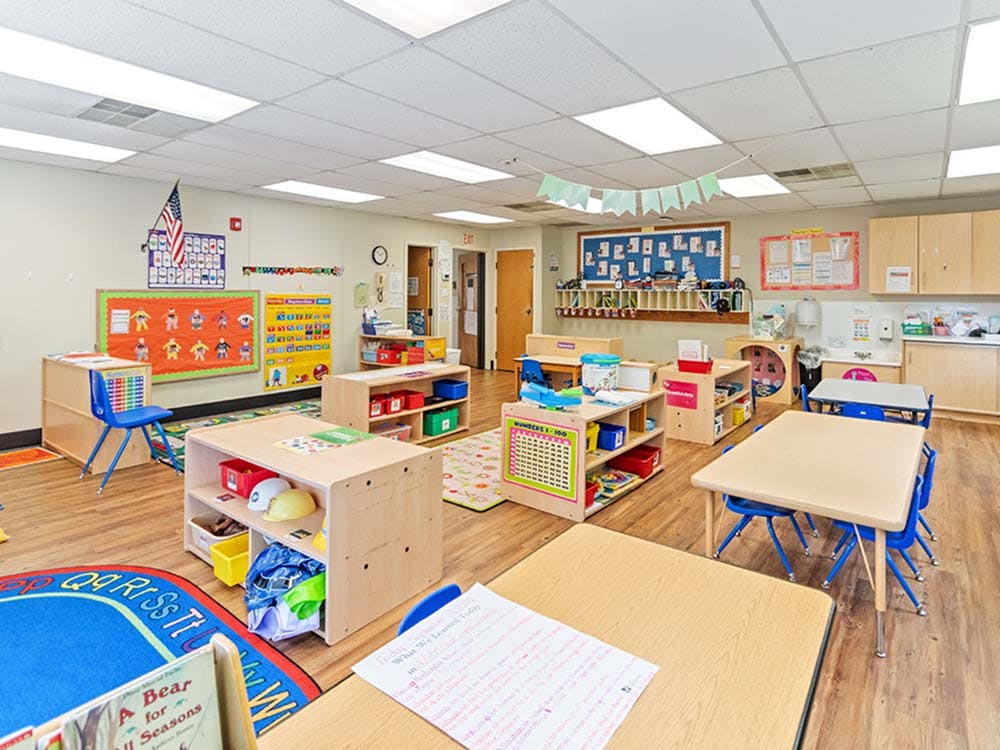 Empty colorful children's classroom with small tables and chairs