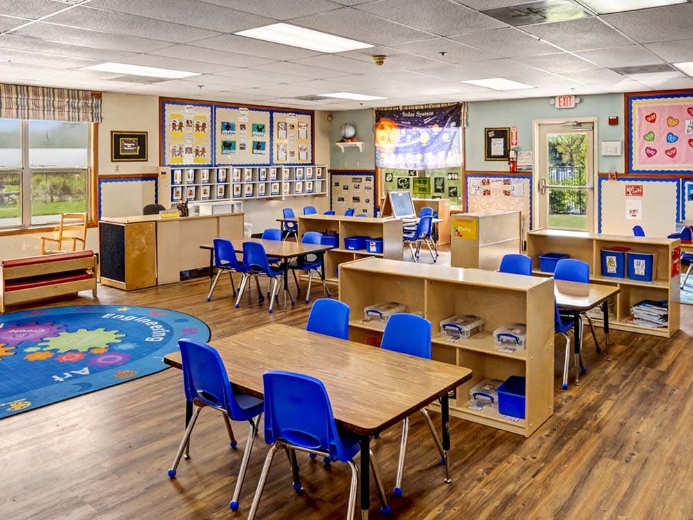 Empty classroom with small tables and blue chairs