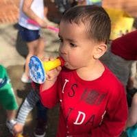 Child playing with a toy horn