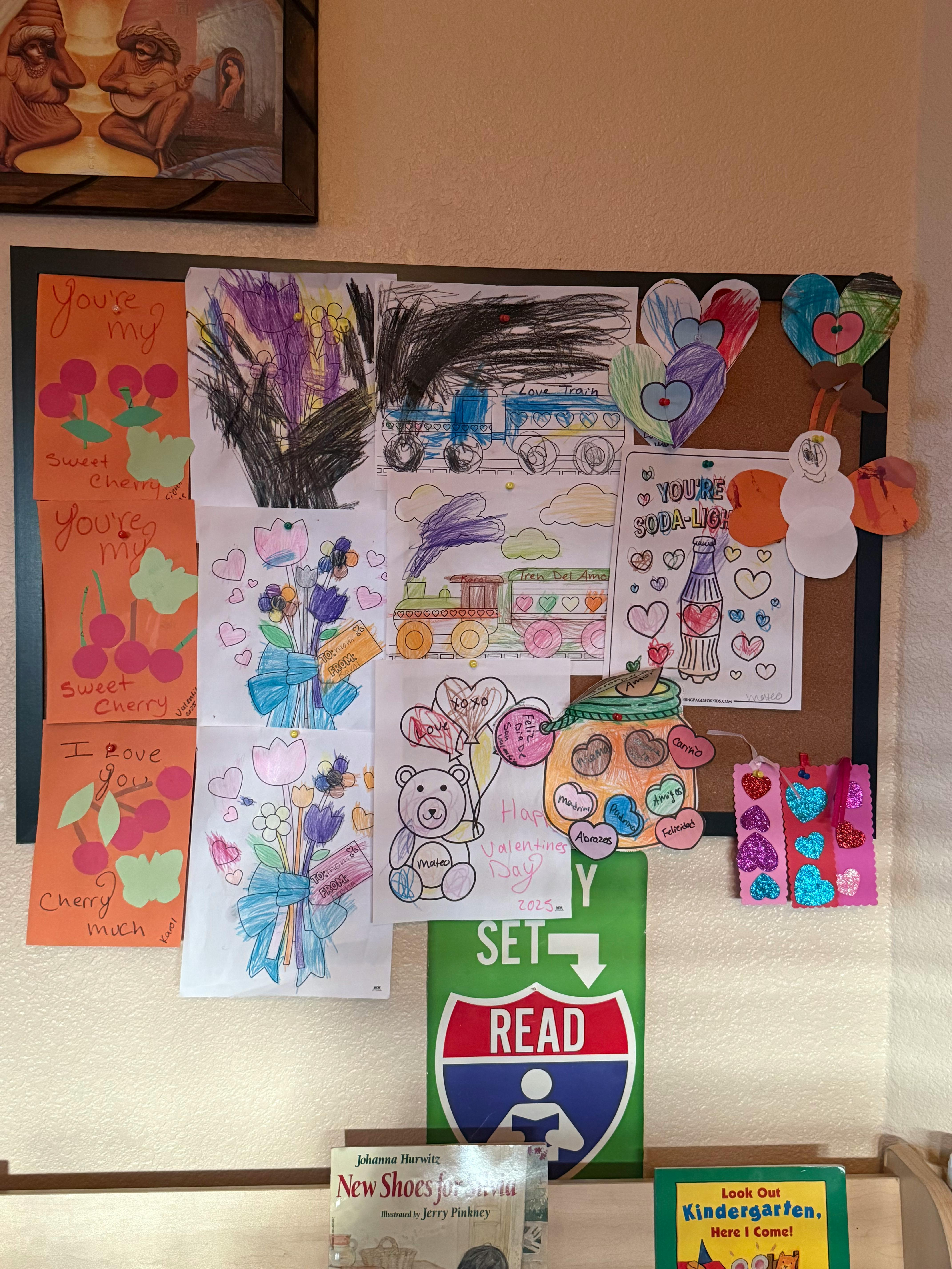 Bulletin board with various children's drawings and crafts