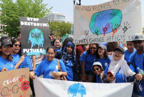 Group of people holding signs and banners about climate change