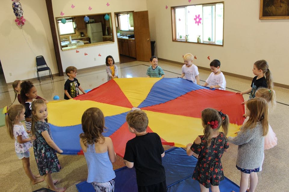 Children playing with a colorful parachute
