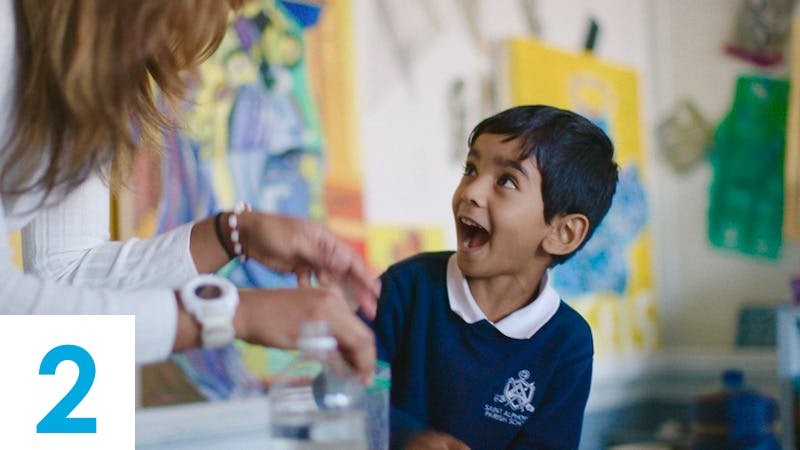 Child looking up at a person in a classroom