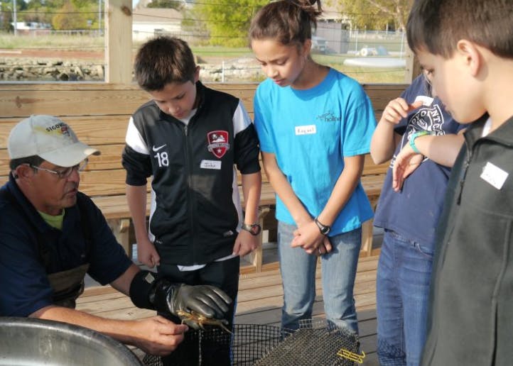 Adult showing children a small animal in a glove