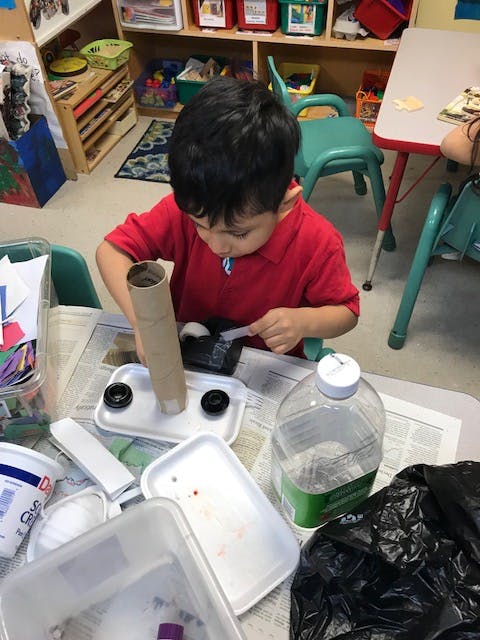 Child working on a craft project at a table