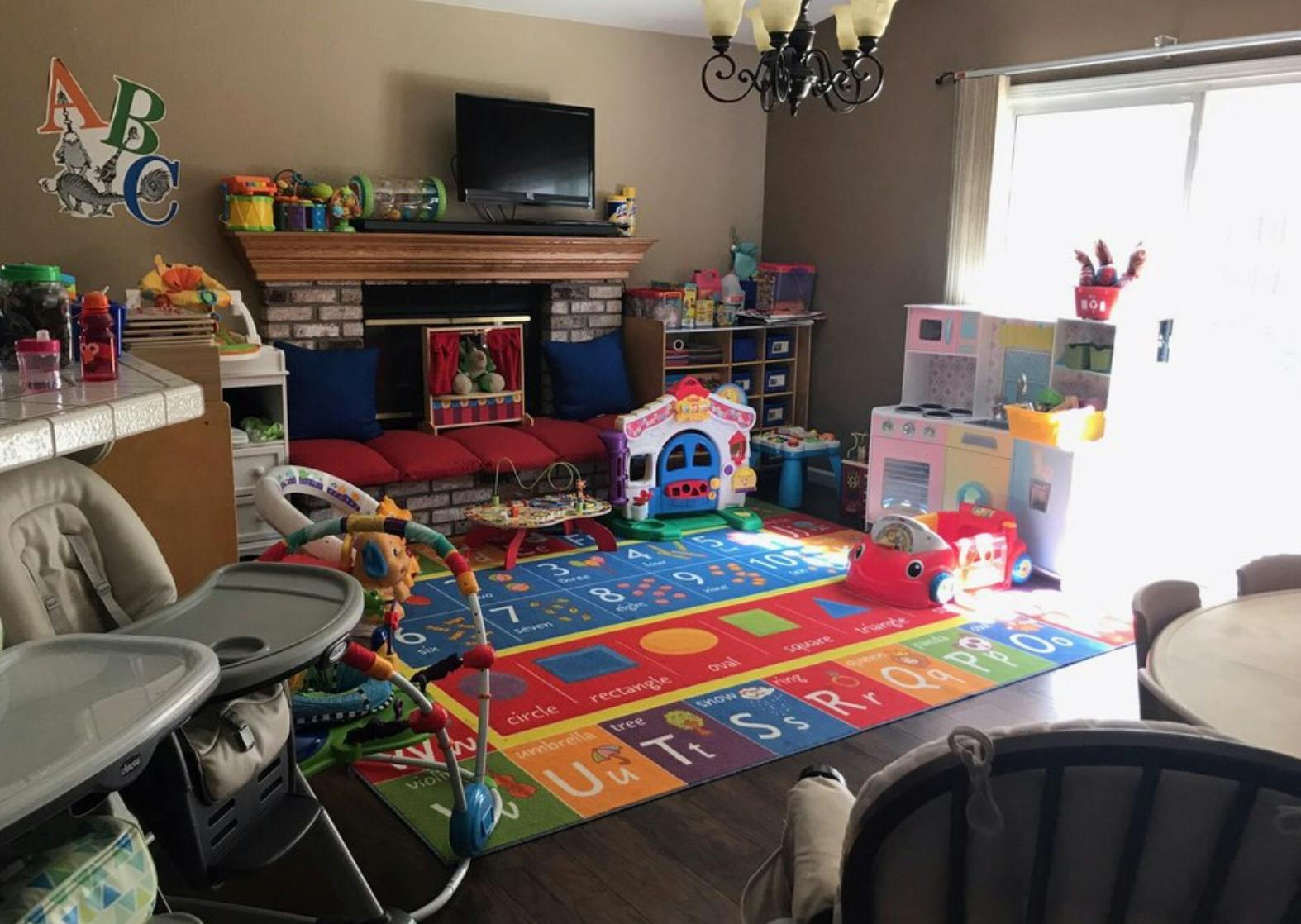 Playroom with colorful alphabet rug, toys, and baby equipment