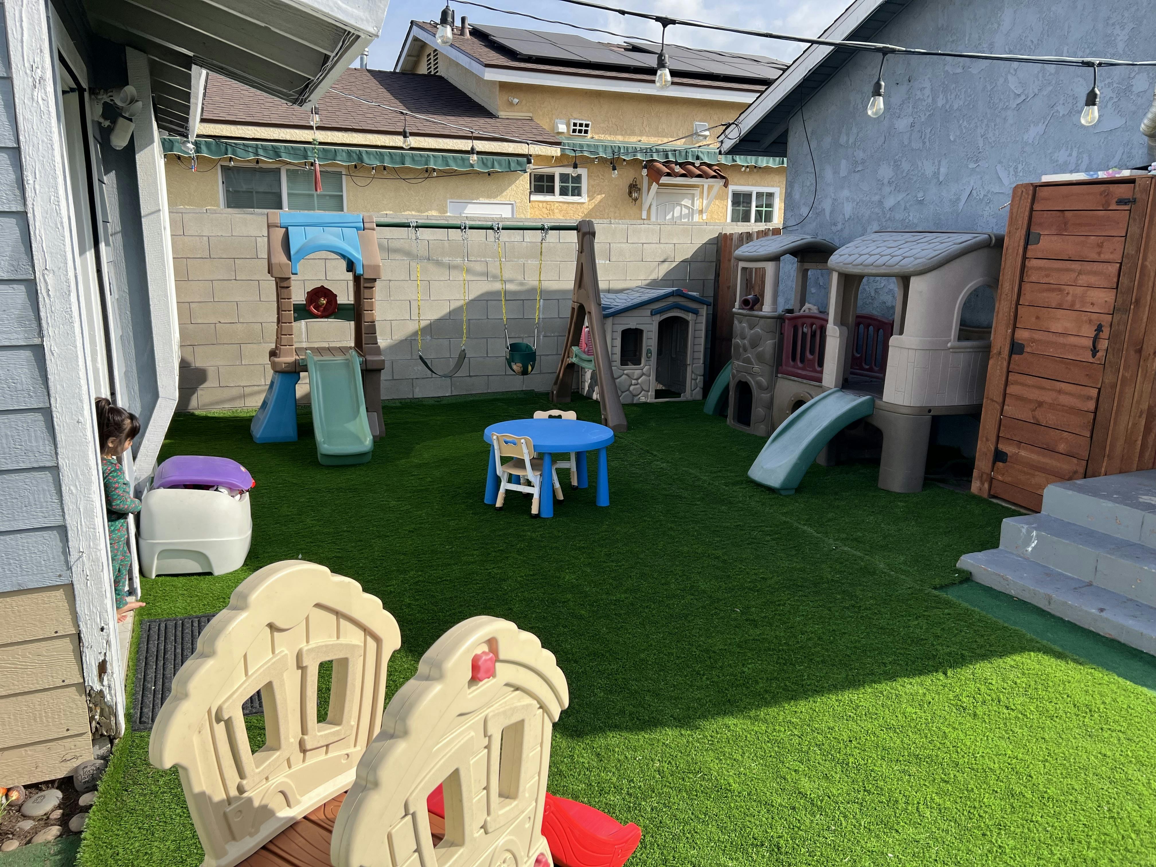 Backyard with artificial turf and children's play structures