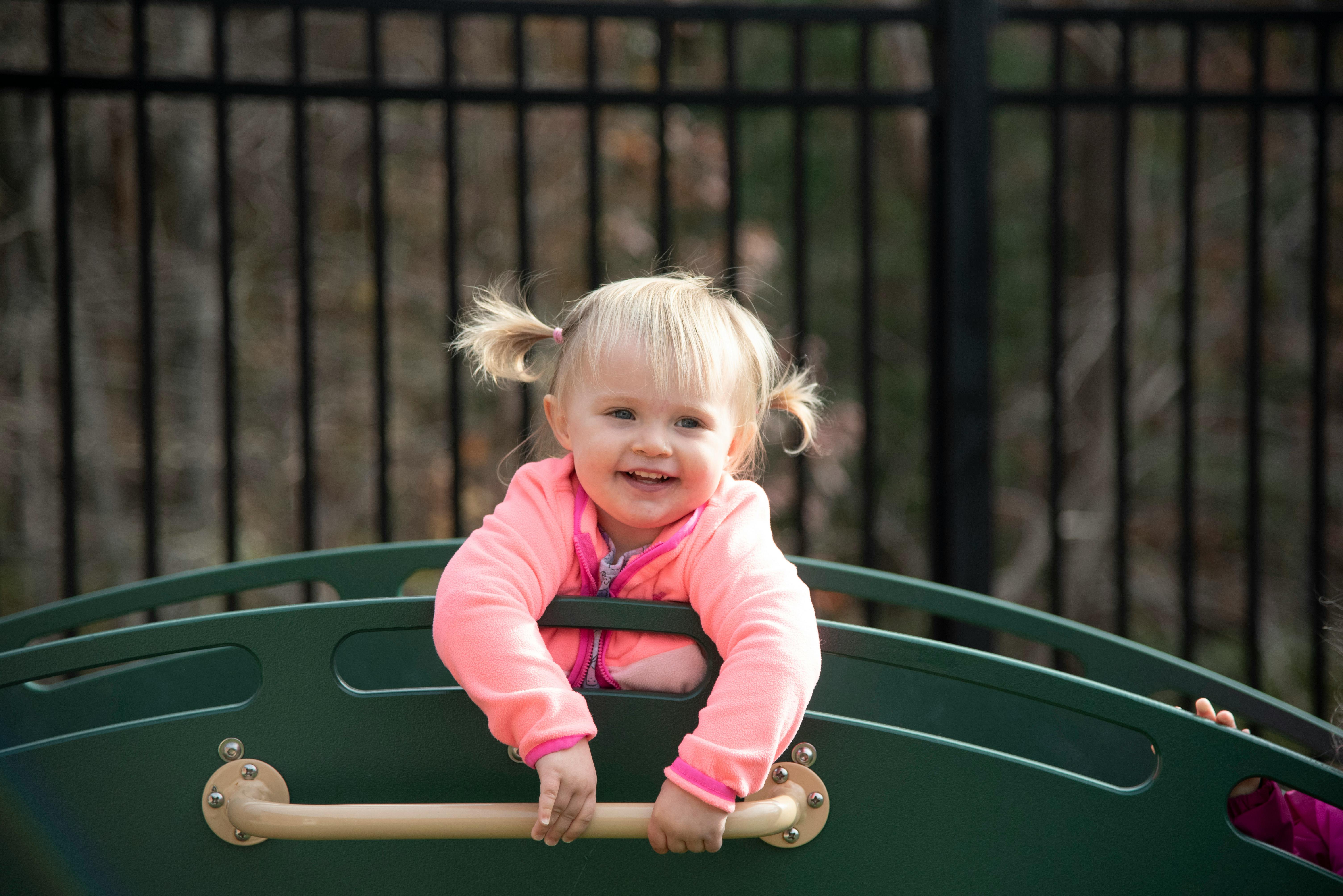 Child with pigtails on playground equipment