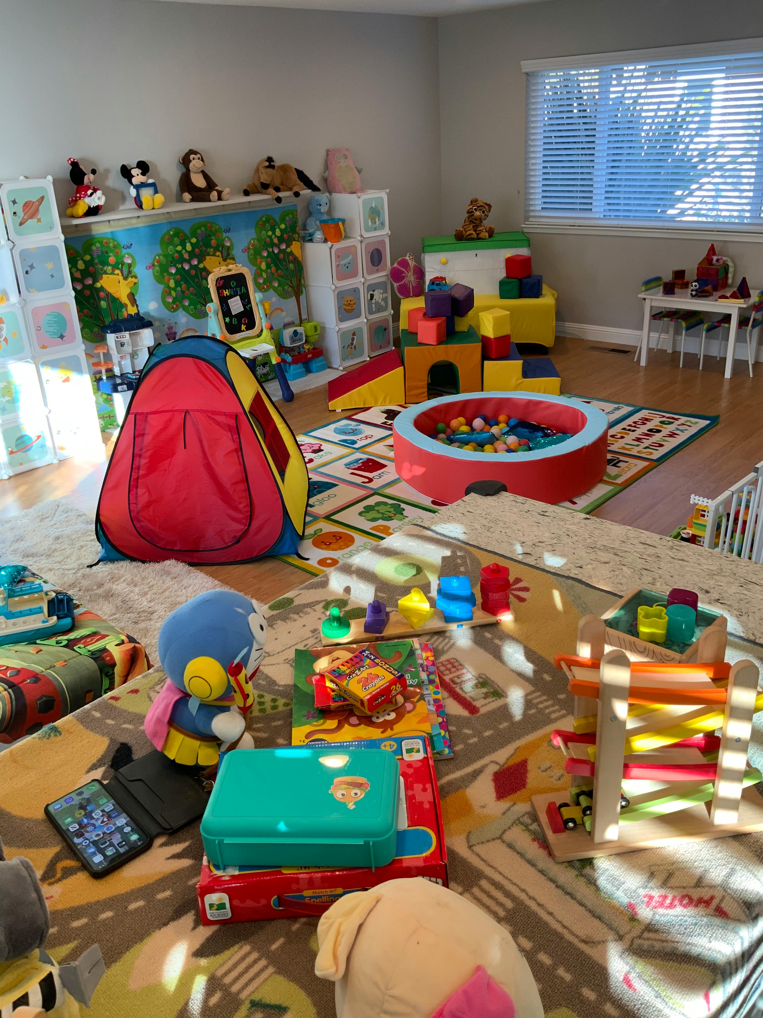 Playroom with a tent, ball pit, and various toys on the floor