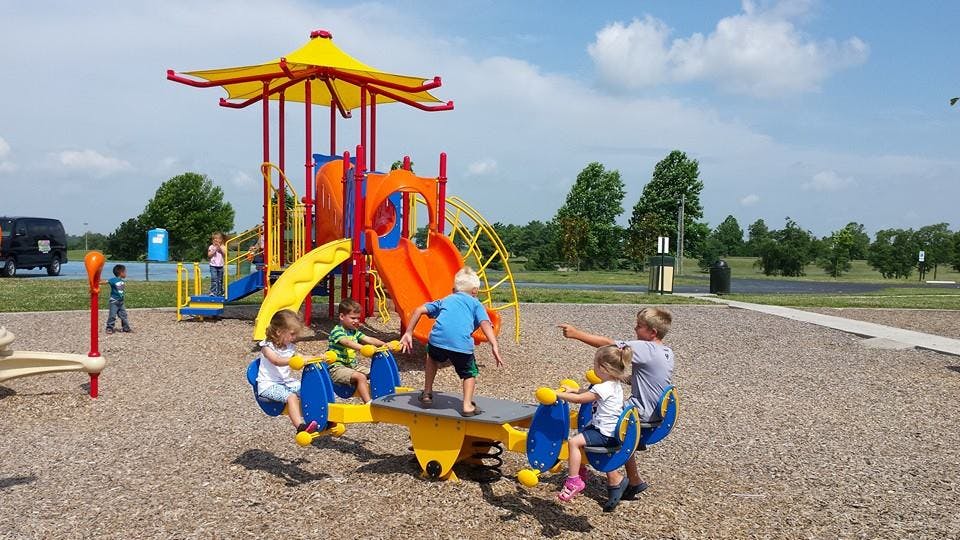 Children playing on a seesaw and playground equipment