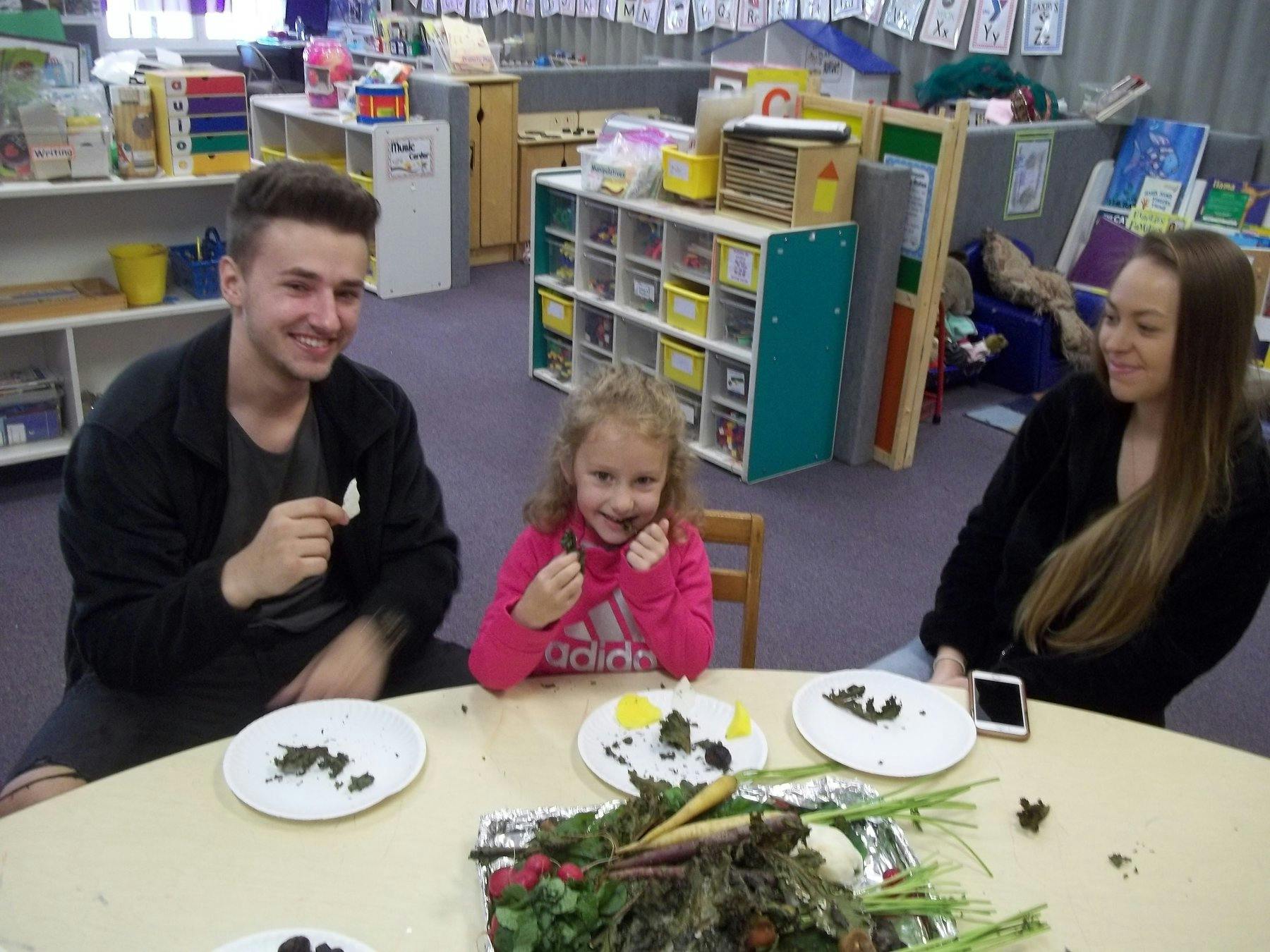 Two adults and a child sitting at a table with plates of food