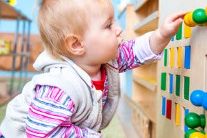 Child playing with a colorful activity board