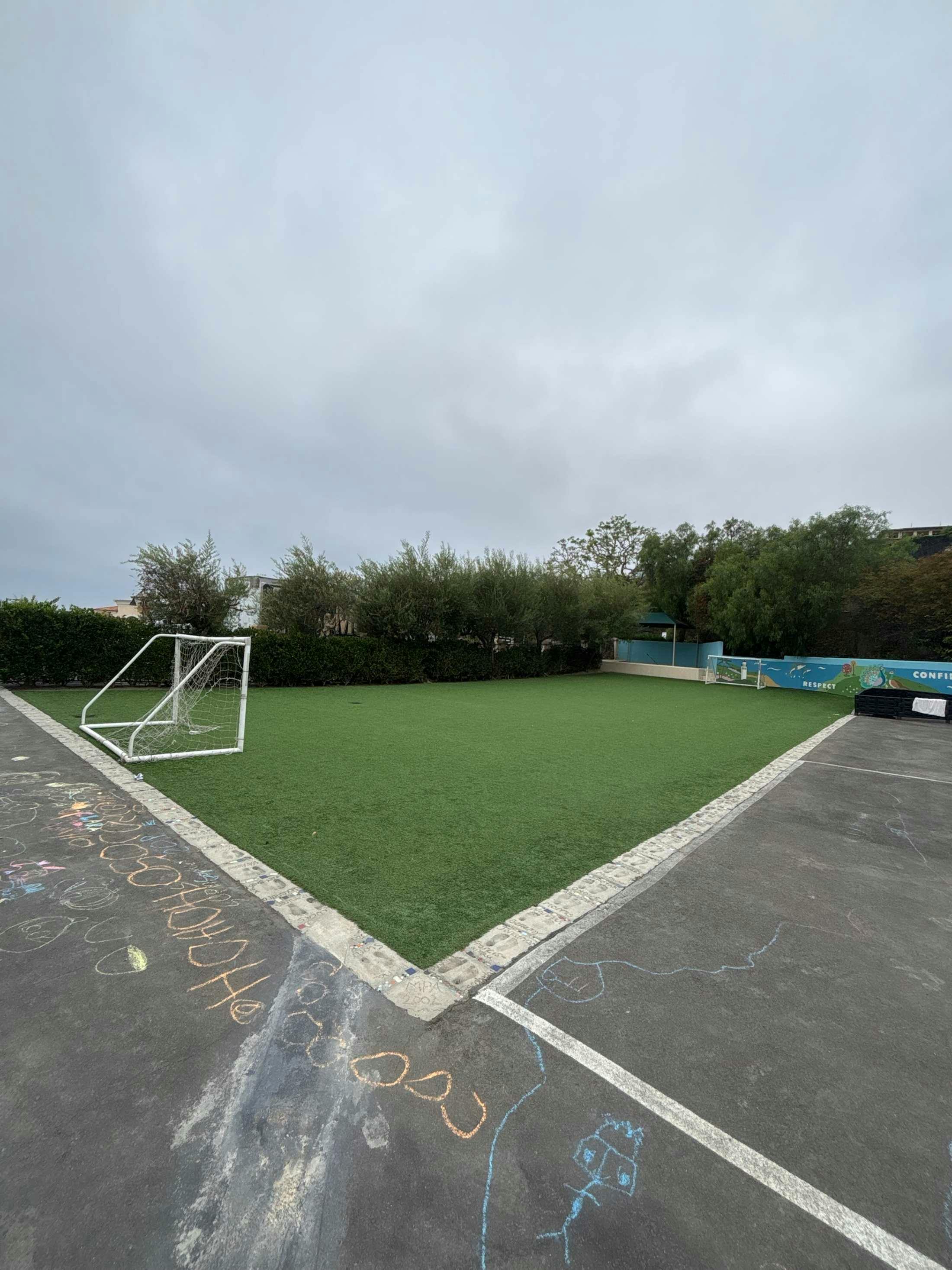 Small artificial turf soccer field with goals on a school playground