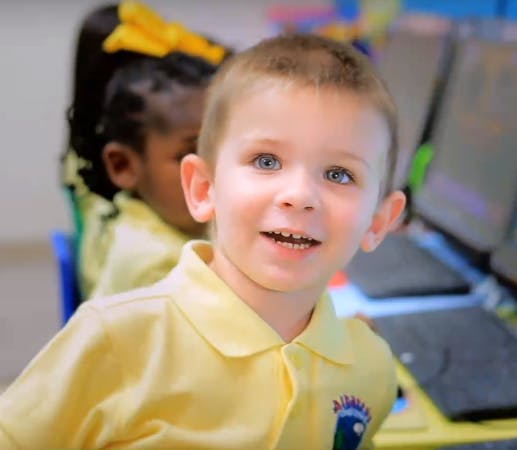 Child in a yellow shirt smiling