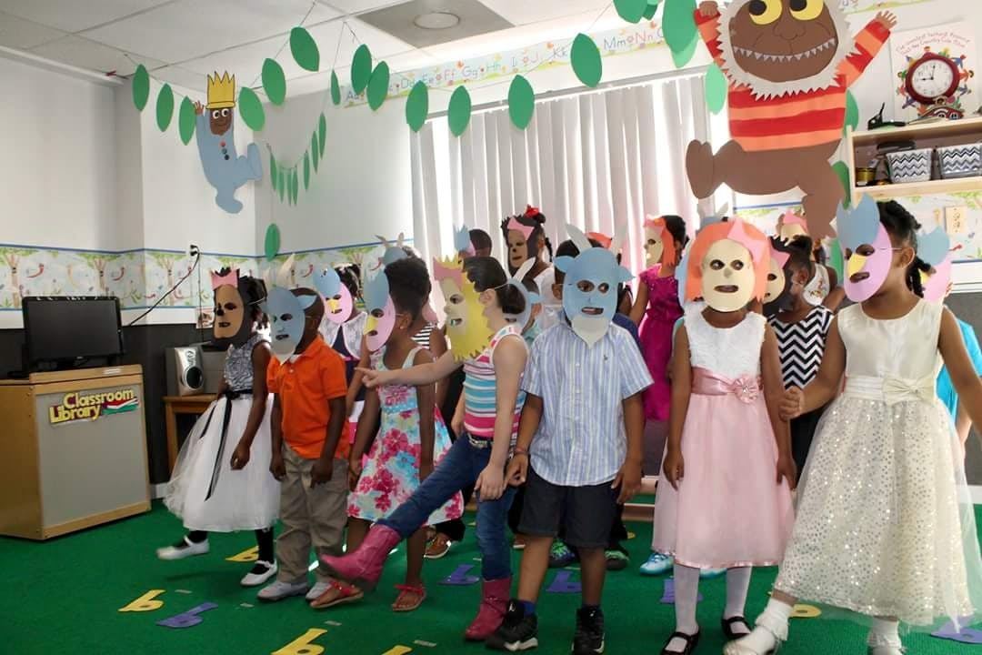 Children in a classroom wearing masks and holding masks