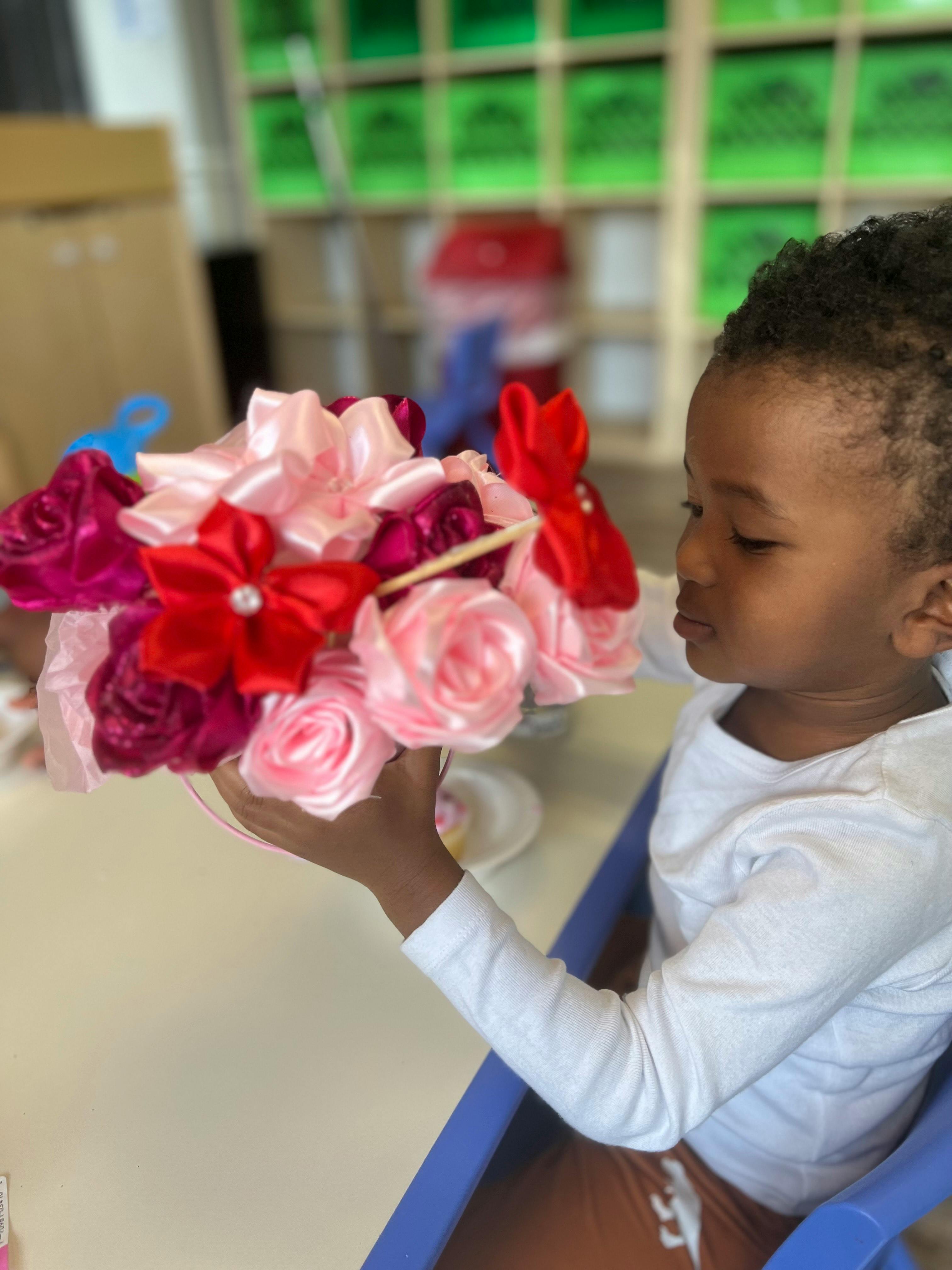 Child holding a bouquet of fabric flowers