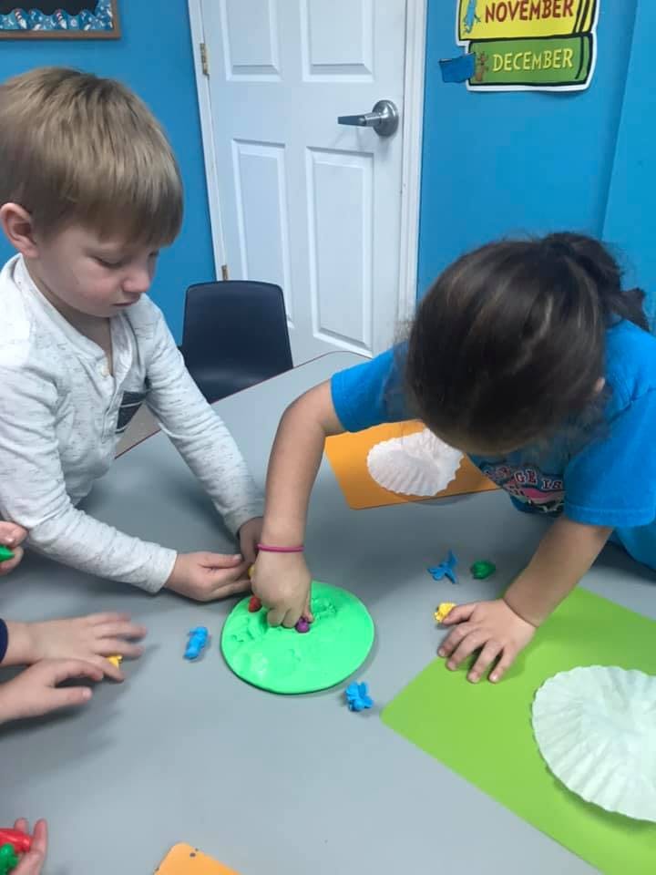 Two children playing with colorful objects on a table