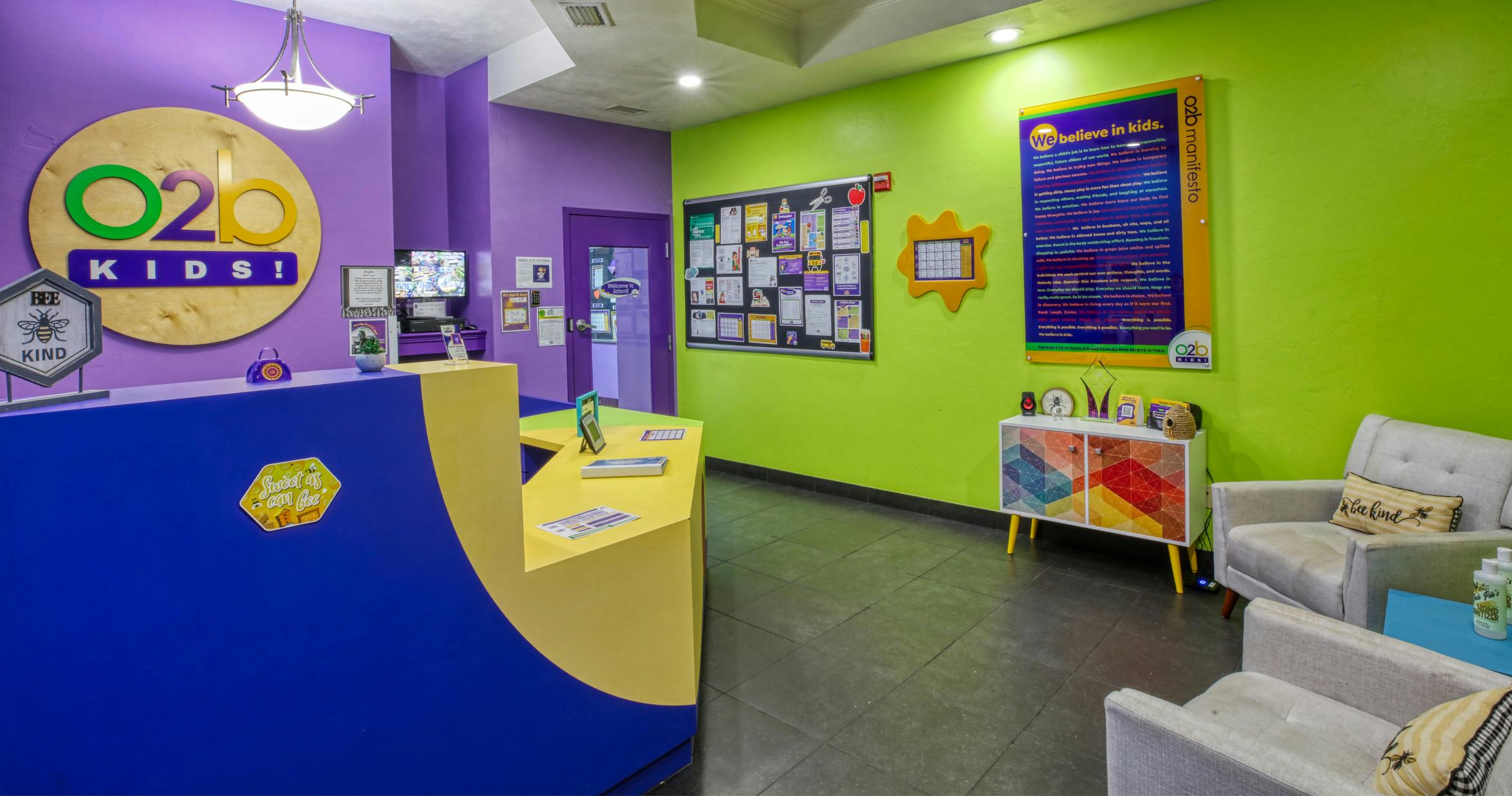 Colorful lobby of a kids' center with a blue and yellow reception desk