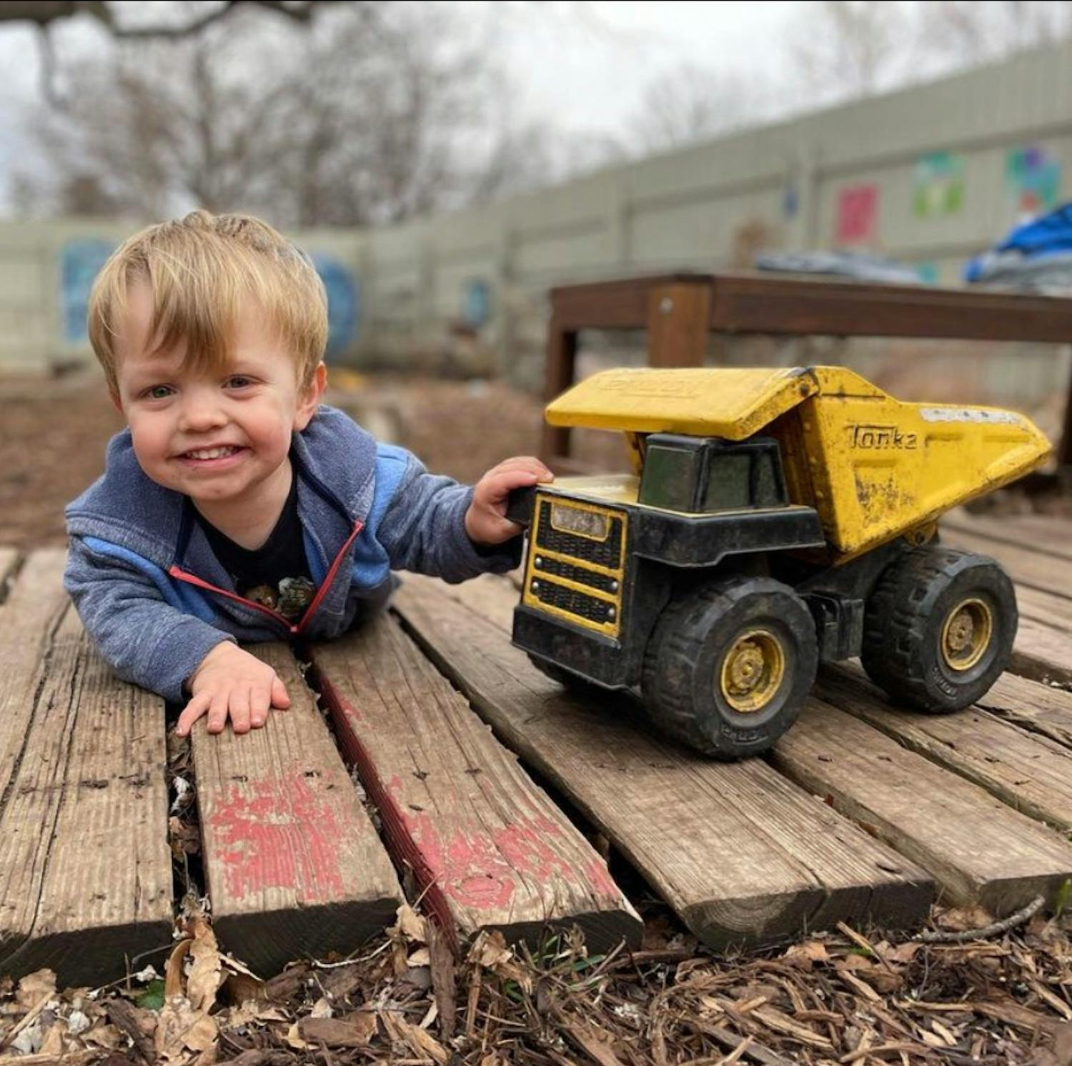 Child playing with a toy dump truck outdoors